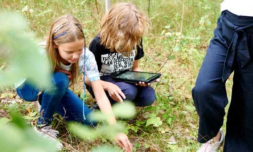 Tre elever som har undervisning ute