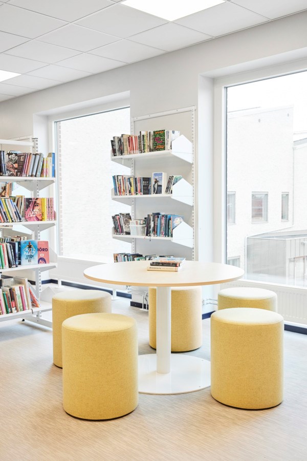 sittepuffer og rundt bord i biblioteket